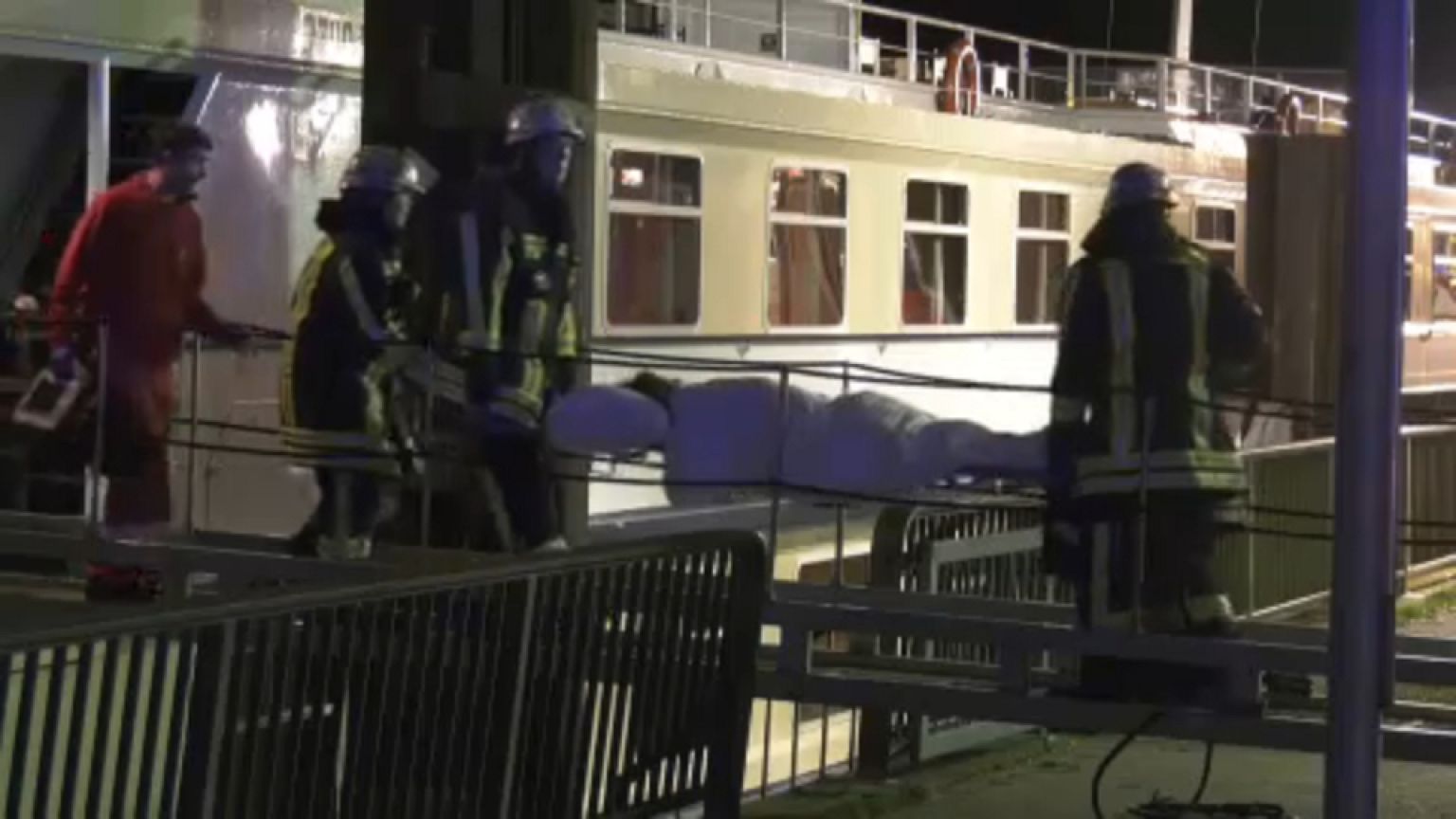 Rettungskräfte bringen einen verletzten Passagier von Bord. 