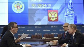 Russian President Vladimir Putin (R) visits the Central Election Commission