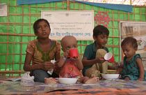 Vier Kinder sitzen in einem Unicef-Zelt auf dem Boden.