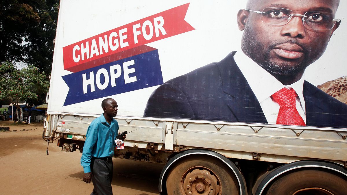 A supporter of George Weah listens to the announcement of the presidential 
