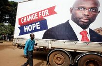 A supporter of George Weah listens to the announcement of the presidential 