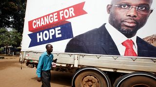 A supporter of George Weah listens to the announcement of the presidential