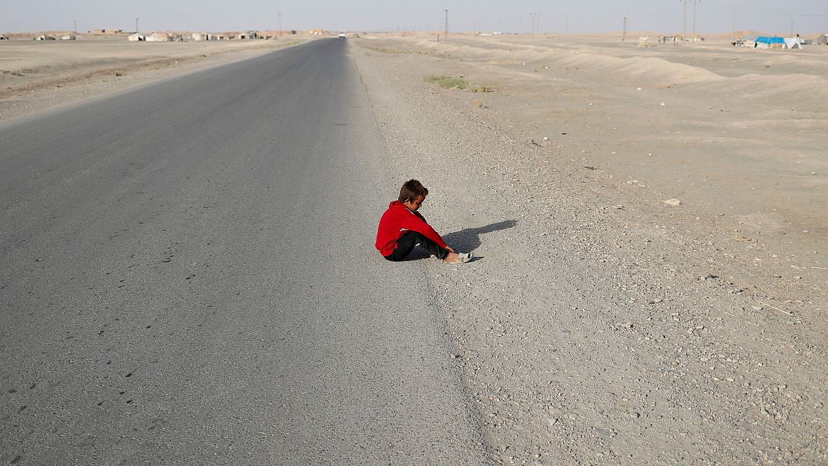 طفل شردته الحرب يجلس على قارعة الطريقة بقرية كرامة شرق الرقة