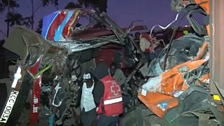 Rescue workers comb through the wreckage of a crashed bus in Kenya
