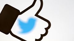 A 3D-printed Facebook like button is displayed in front of the Twitter logo
