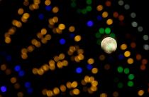 The 'supermoon' full moon is seen through Christmas lights in Valletta