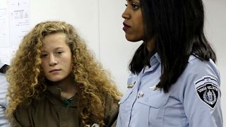 Palestinian teen Ahed Tamimi in court escorted by Israeli prison officer