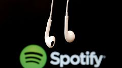 Headphones are seen in front of a logo of online music streaming service