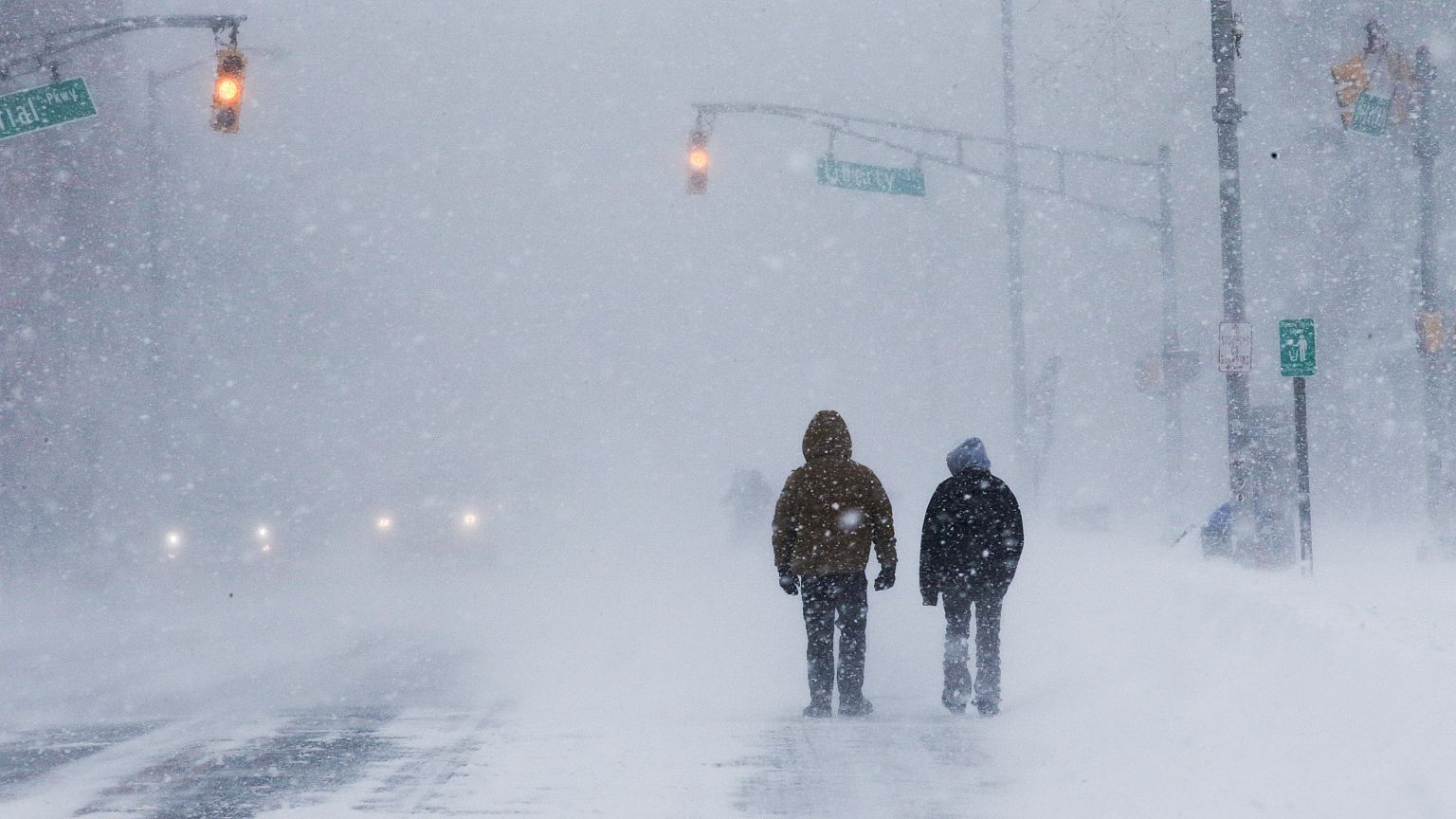People struggle against wind and snow at the Jersey shore in Long Branch NJ