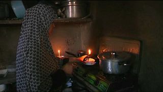 A Gaza resident cooks by candlelight