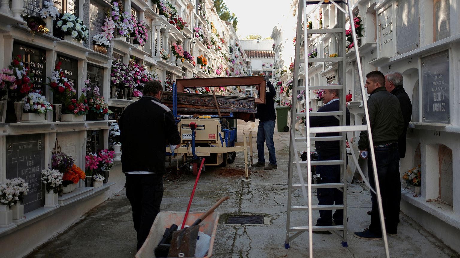 Unemployed Andres Mateo, 40, opens the cover of a coffin as he exhumes