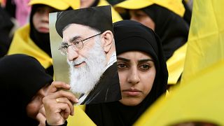 A woman carries a picture of Iran's Supreme Leader Ayatollah Ali Khamenei a