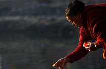A devotee offers prayer along the bank of Hanumante River