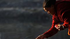A devotee offers prayer along the bank of Hanumante River