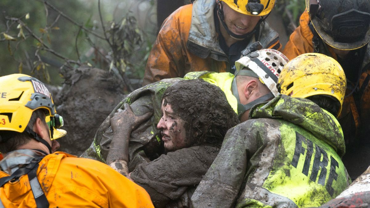  Emergency personnel carry a woman rescued from a collapsed house in USA