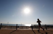 A woman exercises on a hot day in Barceloneta beach in Barcelona, Spain.