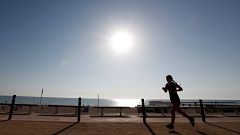 A woman exercises on a hot day in Barceloneta beach in Barcelona, Spain.