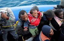 Migrants in a dinghy are rescued by Libyan coast guards