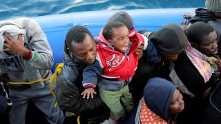 Migrants in a dinghy are rescued by Libyan coast guards
