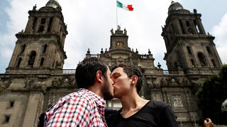 A couple kiss each other in front of the cathedral during a march