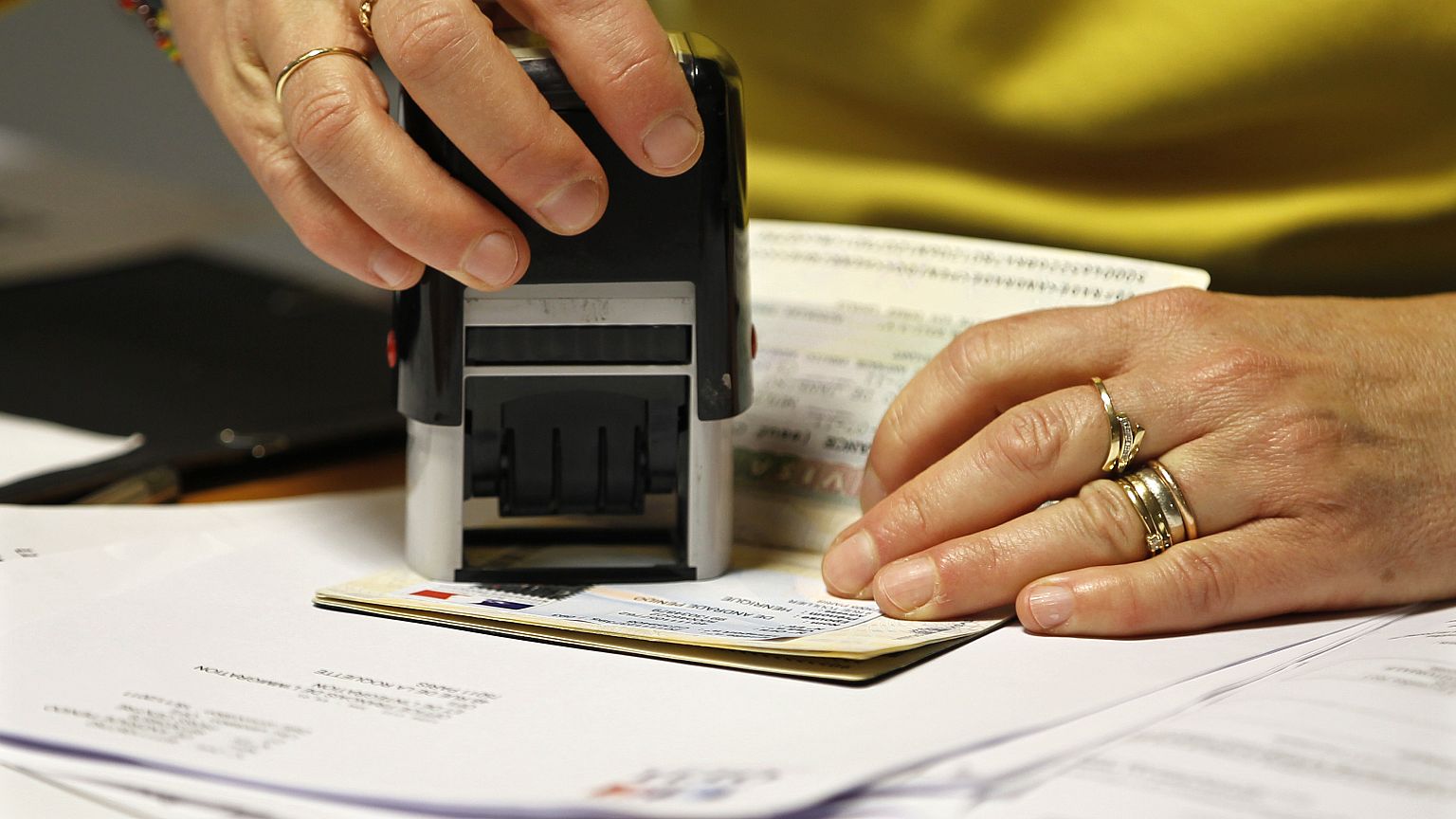 Une employée tamponne un visa
