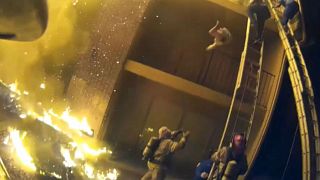 Firefighter catches child dropped from second floor of burning building