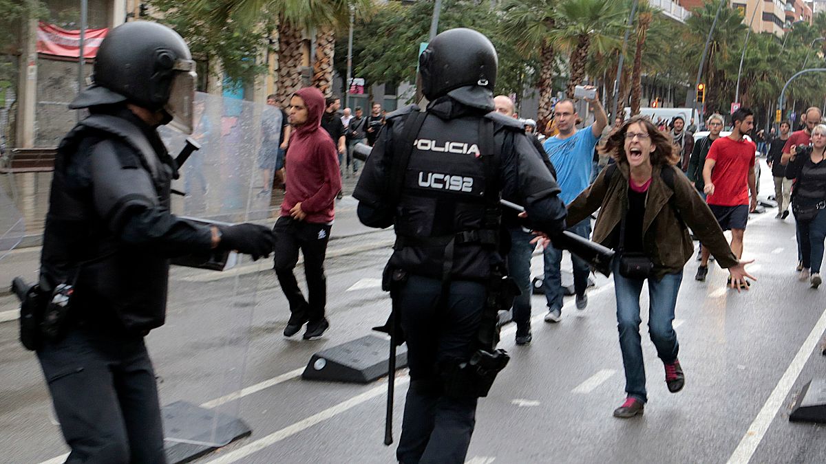A woman yells at riot police near a a polling station