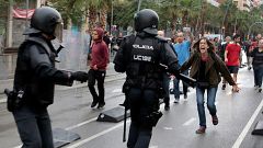 A woman yells at riot police near a a polling station