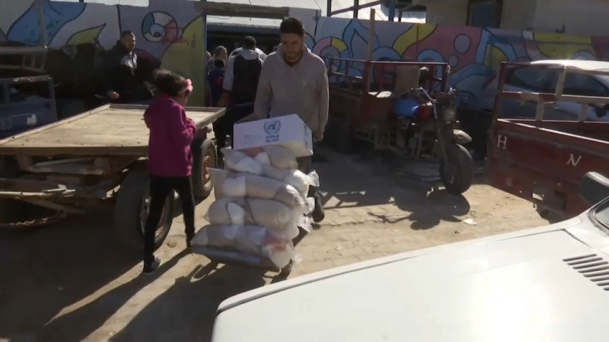 Ein Palästinenser befördert UN-Hilfslieferungen auf einer Sackkarre.