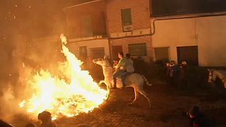 Horse riders trot through roaring flames to mark a 500 year old Spanish festival
