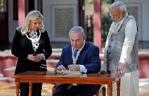 Israeli Prime Minister Netanyahu writes a message in the visitor's book 
