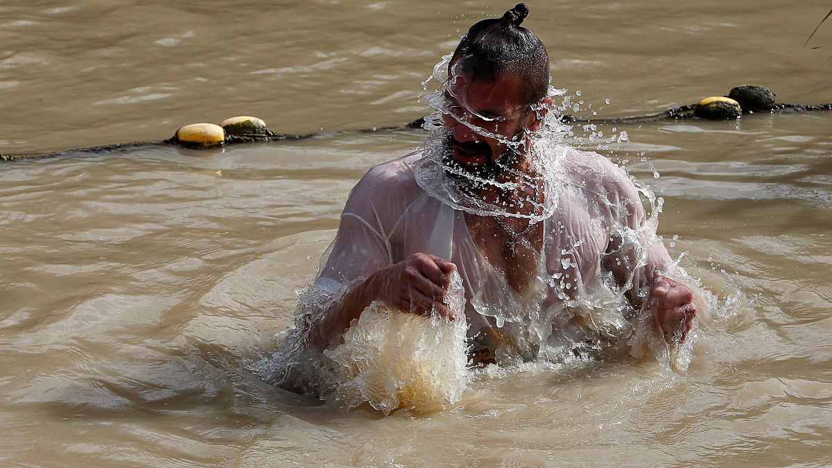 Un pélerin baptisé dans les eaux du Jourdain