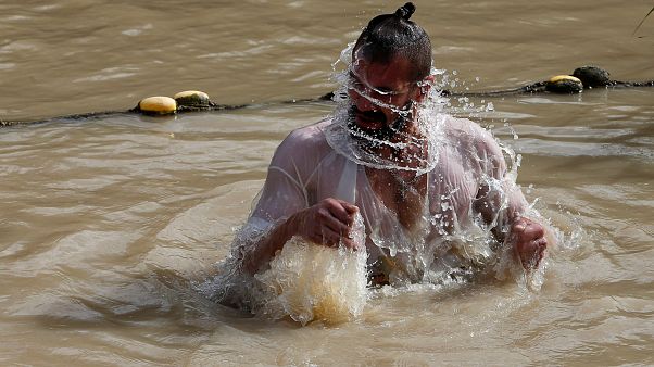 Un pélerin baptisé dans les eaux du Jourdain Un pélerin baptisé dans les eaux du Jourdain
