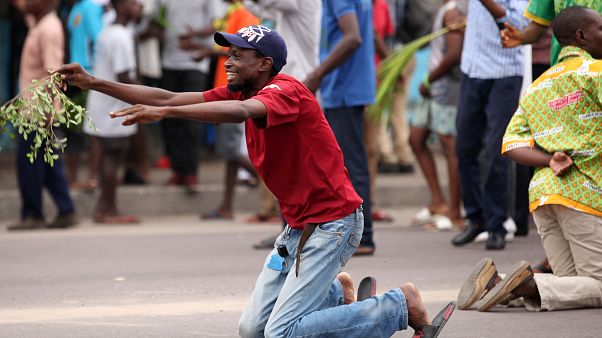 Un manifestant anti-Kabila à genoux devant la police à Kinshasa. Un manifestant anti-Kabila à genoux devant la police à Kinshasa.