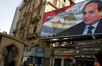 People walk by a poster of Egypt's President Abdel Fattah al-Sisi in Cairo