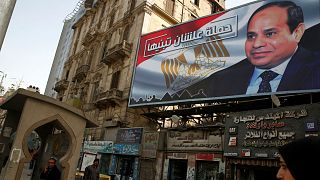 People walk by a poster of Egypt's President Abdel Fattah al-Sisi in Cairo