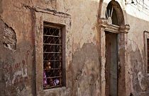 فتاة  تطل من نافذة منزلها في بنغازي، ليبيا.