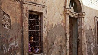 فتاة  تطل من نافذة منزلها في بنغازي، ليبيا.