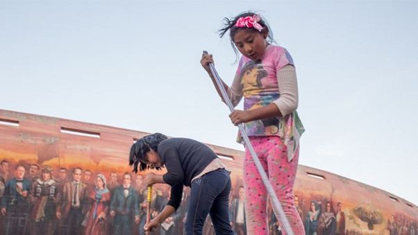 An 8-year-old and her friend sweep the pavement in La Paz. An 8-year-old and her friend sweep the pavement in La Paz.