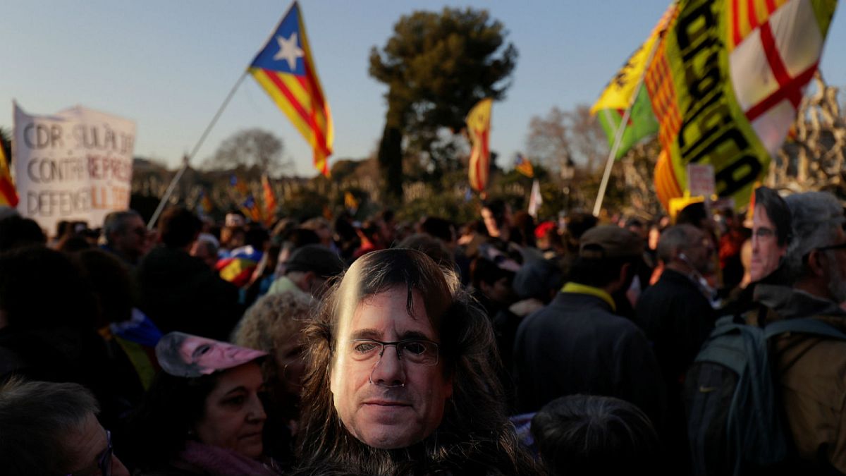 A demonstrator wears a mask depicting ouster separatist leader Puigdemont