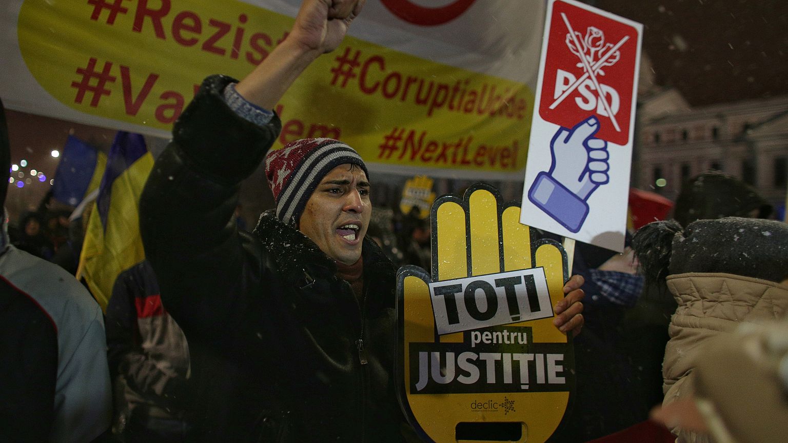 Ein Mann streckt seine Faust in die Luft während einer Demo in Bukarest.