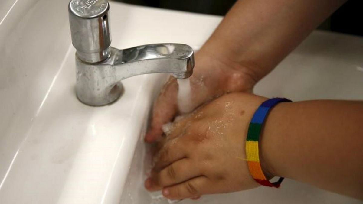 طالبة في مدرسة في لوس انجليس تغسل يديها