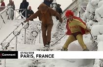 A super hero and his sidekick snow down the slopes of Sacre Coeur