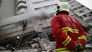 Tűzoltók a február 6-i földrengésben összedőlt egyik épületnél Hualienben