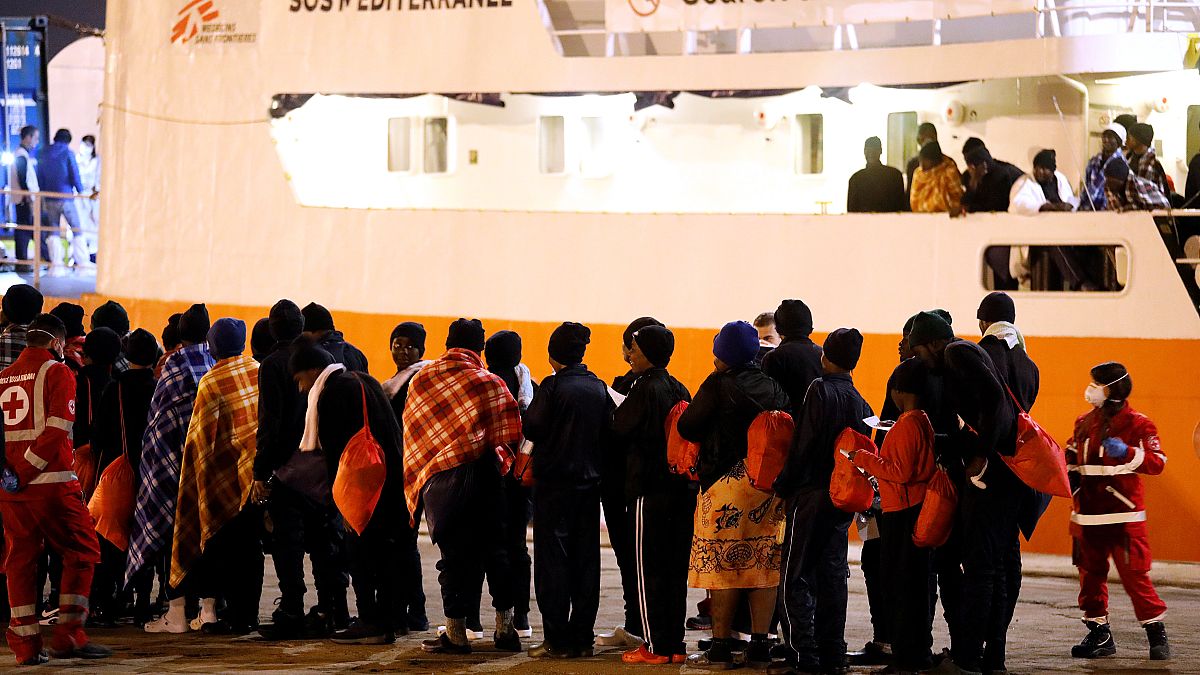 Migrants disembark from the MV Aquarius, a search and rescue ship run in pa