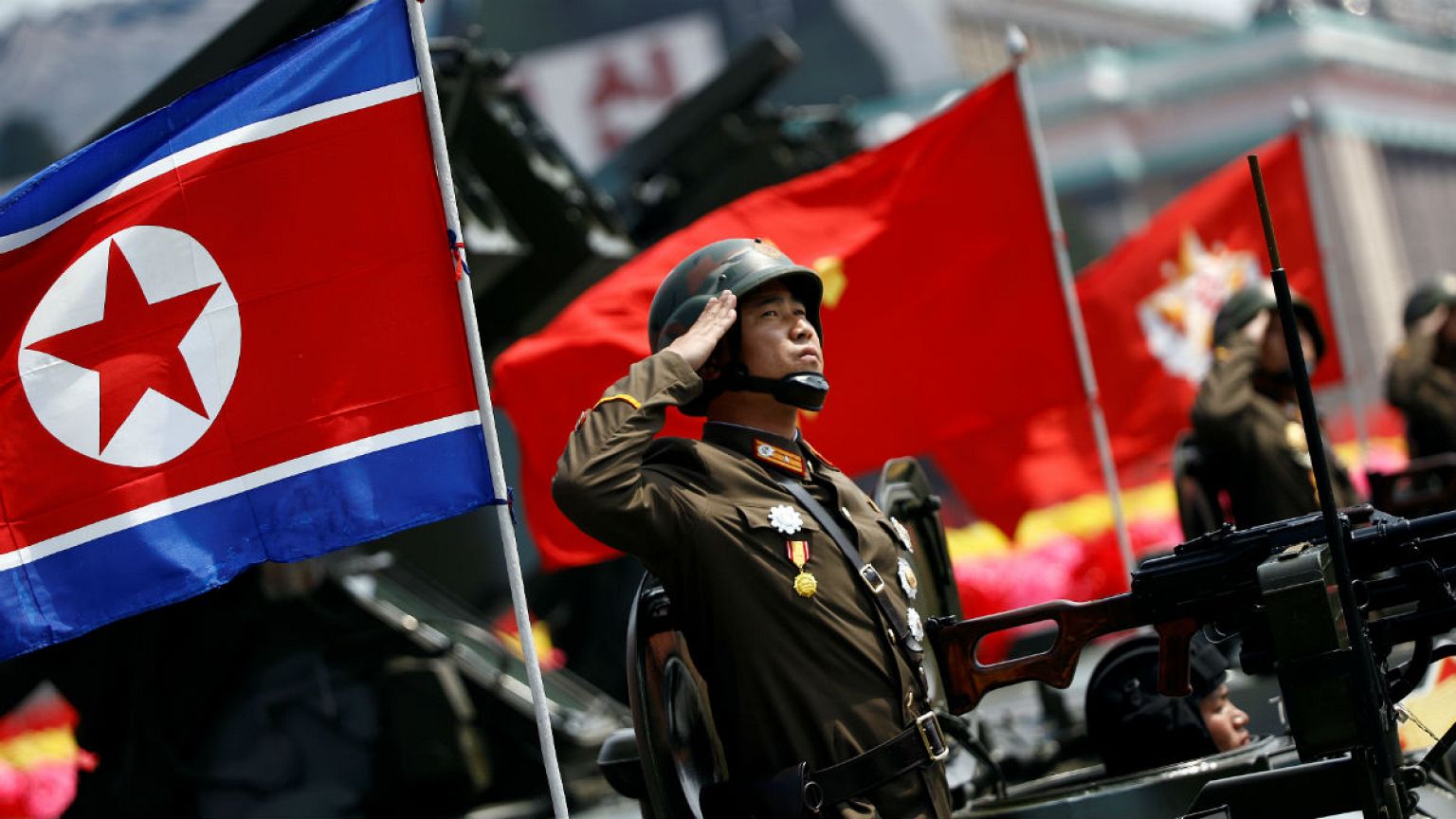 file photo north korea soldier salutes from atop an armoured vehicle