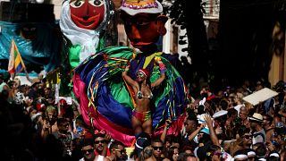Eine bunt gekleidete Frau tanzt beim Karneval in Rio de Janeiro.