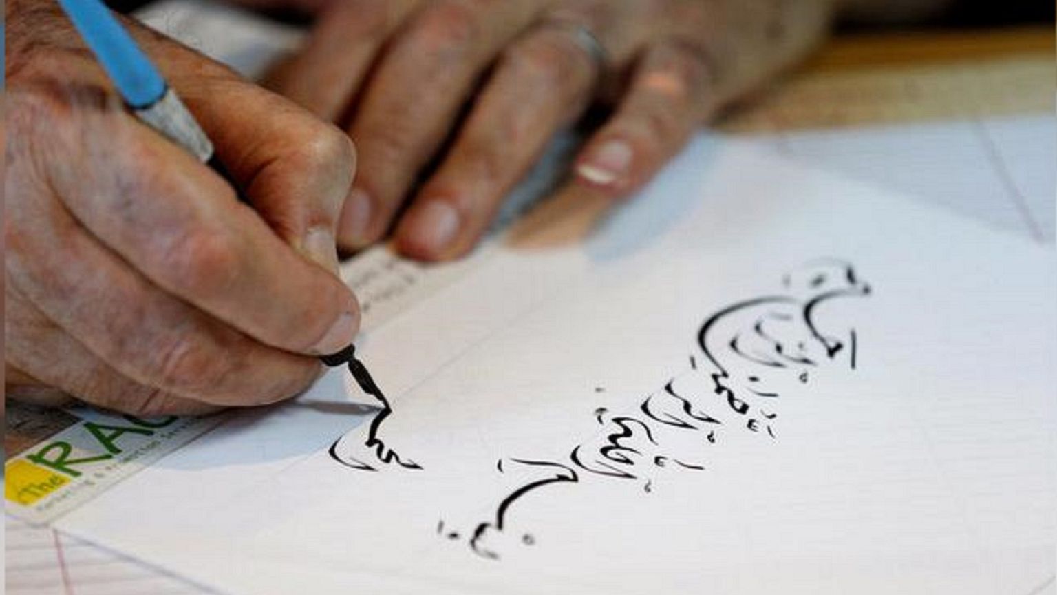 خطاط يكتب آية من القرآن
