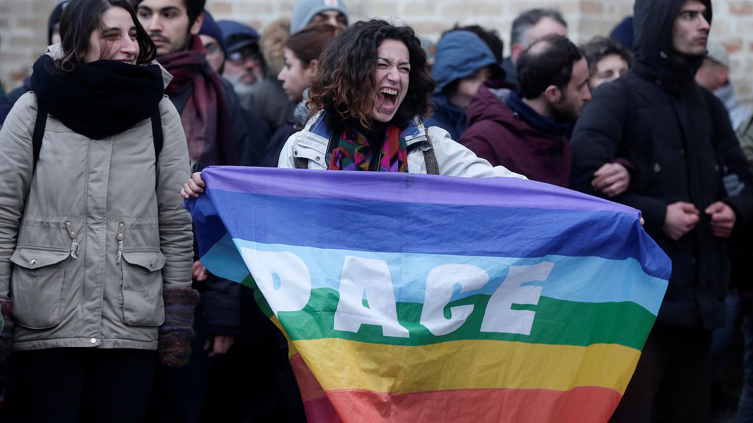 Demonstrantin hält Pace-Fahne.
