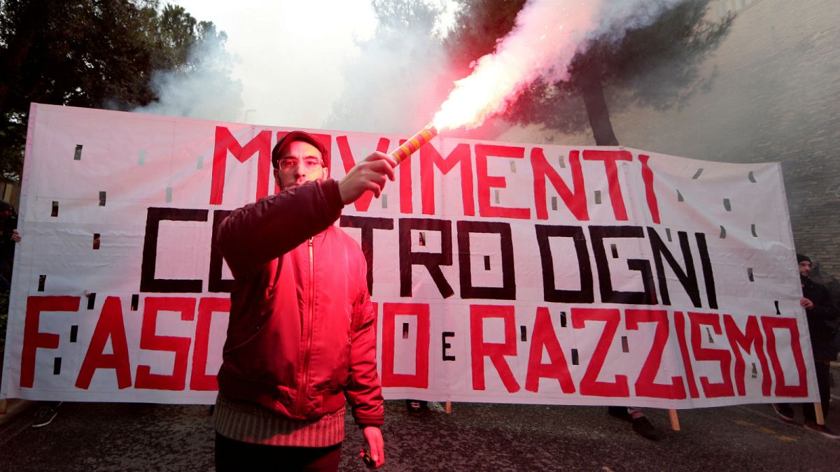 A banner reads "Movements against fascism and racism" in Macerata, Italy